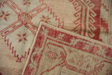 Folded corner of a vintage Oushak rug shows its hand-knotted texture and original side selvage.