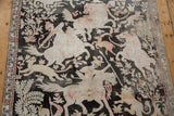 Distressed Qom rug edge, showing faded ivory floral border and pictorial hunting scene.
