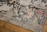 Textured distressed pile with blush floral patterns and ivory border on the vintage Qom rug.