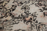 Distressed vintage Qom rug showing worn pictorial animals in charcoal, ivory, and blush tones.