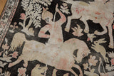 Worn texture of a pictorial hunting scene rug, showing horseback archer, rabbit, and foliage.