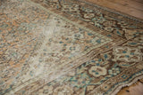 Distressed Hamadan carpet with worn ivory-beige field and dark brown patterned border.