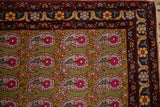 Close-up of the boteh paisley design and arabesque border of a vintage Persian rug.