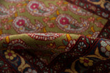 A folded view showing the even, short wool pile and sage green Boteh motifs.