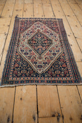 Vintage Senneh rug corner, showing blue selvage, delicate fringe, and geometric floral border.