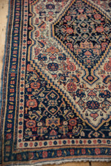 Vintage Senneh rug detail: navy, ivory border, stepped patterns, visible knot heads, blue selvage.