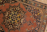 Vintage Tabriz rug corner, displaying serpent border, pale rust field, and charcoal spandrel.