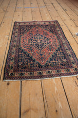 Distinctive side border and Herati relief design on vintage Senneh rug in madder, navy, and ivory.