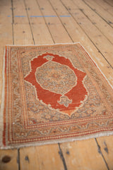 A vintage Tabriz rug from a high angle, featuring its rust medallion and intricate sand field.