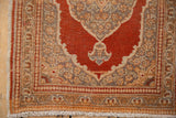 Corner spandrel detail on a vintage Tabriz rug with a rust field and intricate floral borders.