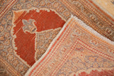 The hand-knotted back and secured fringe of a vintage Persian Tabriz rug corner.