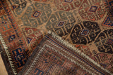 Folded corner of an antique Belouch rug reveals the dense wool pile and detailed woven foundation.