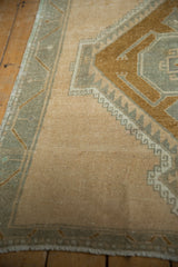 Distressed vintage Oushak runner texture, ivory field, bronze, and slate geometric patterns.