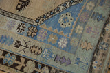 Distressed vintage Oushak border patterns with germinating plants in blue, green, and brown.