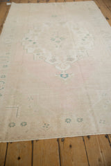 Low angle view of the distressed Oushak runner, showing its length and faded blush palette.