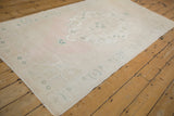 Distressed Oushak runner at an angle, showing its soft ivory, blush, and pale green palette.