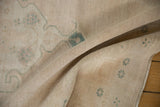 Evenly worn low pile and soft, hand-knotted texture of a distressed vintage Oushak rug.