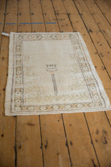 Vintage distressed Oushak rug featuring faded ivory and sand prayer design with lantern motif.