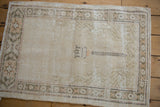 Distressed ivory vintage Oushak rug, showing prayer motif with time-softened neutral tones.