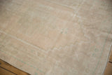 Distressed pile of a vintage Turkish Oushak, showing muted ivory, beige, and faint foundation.