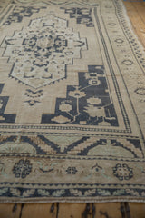 Detail of vintage distressed Oushak rug showing stepped geometric medallion, dusty navy and ivory tones.