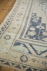 Distressed vintage Oushak rug details: stepped border, geometric floral motifs, navy, ivory, seafoam.
