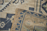 Distressed Oushak rug, beige and blue geometric motifs, short pile, restored selvage.