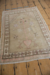 Distressed Oushak rug detail: time-softened beige, pale pink tree-of-life, and floral border.