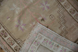 Distressed beige pile and tightly woven foundation of a Vintage Oushak rug with pink hues.