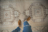 Distressed Oushak runner, showing muted beige, aubergine geometric guls with even wear and faint blue.
