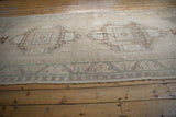 Distressed Oushak runner border, with faded geometric patterns in pale mauve and ivory.