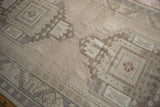 Distressed vintage Oushak runner's geometric guls, exhibiting even pile wear and faint foundation.