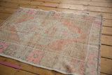 Distressed pile and muted pink, orange, sand geometric pattern on vintage Oushak rug.