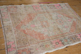 Distressed Oushak rug corner with worn pile, faded pink, orange geometric florals.