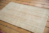 Distressed vintage Oushak rug texture with visible wear, knot heads, and side selvage.