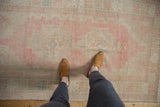 Distressed Oushak rug detail showing blush pink, pale turquoise, and faint foundation.