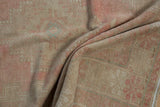 Distressed blush pink and tan Oushak rug pile with even wear and faint foundation.