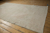 Distressed Oushak runner, soft ivory and beige open field, visible abrash, worn texture.