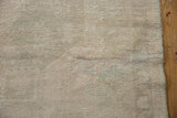 Distressed Oushak rug runner texture with visible knot heads, subtle abrashes, and side selvage.