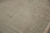 Distressed texture of a vintage Oushak rug runner with visible foundation and light beige tones.