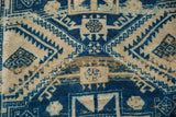 Serrated cobalt blue and beige geometric motifs with distressed texture on vintage Oushak rug.