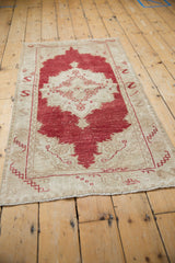 Vintage distressed Oushak runner with cinnabar red field, beige motifs, and serpent border detail.