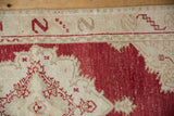 Close-up showing distressed cinnabar red and ivory wool pile with visible knot heads.