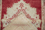 Distressed vintage Oushak rug showing worn cinnabar red pile and hand-knotted foundation.