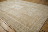 Vintage distressed Oushak carpet with faded neutral tones and intact side selvage.