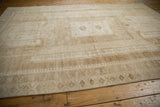 Distressed Oushak rug border detail, featuring muted beige pawn motifs on low pile.