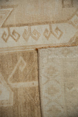 Vintage Oushak rug's tight hand-knotted foundation and distressed ivory beige pile pattern.