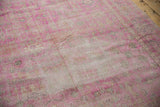 Distressed texture of a vintage Sivas rug with hot pink fuchsia and ivory floral designs.