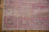 Distressed fuchsia Sivas carpet showing fringed edge and worn floral motifs.