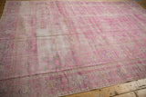 Distressed texture of Sivas carpet, showing hot pink, ivory, and exposed foundation.